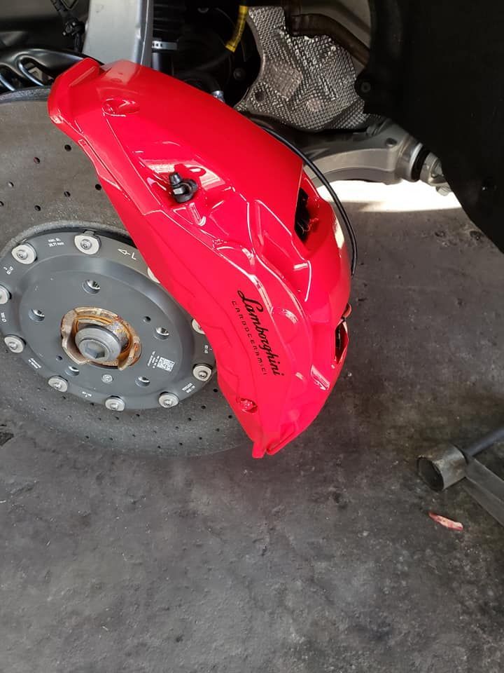 Glossy custom red brake caliper in the workshop